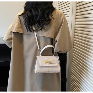 Détail du sac bandoulière crème avec boucle dorée et texture de cuir grain croisé