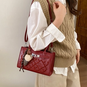 Sac à bandoulière matelassé bordeaux avec emblème couronne et breloque peluche sur mannequin