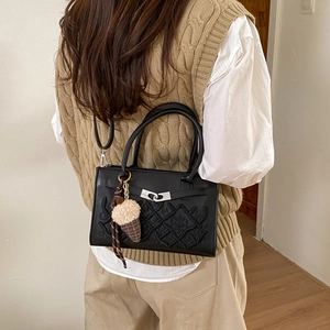 Sac à main brodé noir avec charm glace présenté de dos porté par un mannequin en intérieur