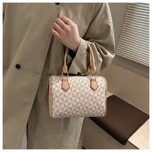 Detail of Boston bag with geometric pattern, leather handles and gold metal rings