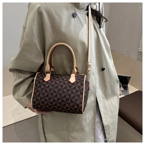 Detail of Boston bag with geometric patterns, beige handles, and red edge paint accents