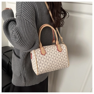 Detail of Boston bag with geometric pattern and brown strap shown on a model