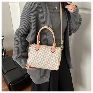 Detailed view of the Boston bag's windmill pattern and contrasting red trim on handles