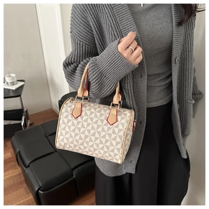 Close-up of geometric pattern boston bag with red edge details and leather handles