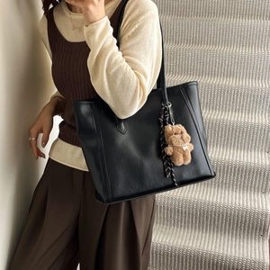Vintage oil wax leather tote bag for women with a cute brown bear charm on a model