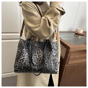 Detail of leopard print tote bag featuring wide jacquard strap and dual black handles
