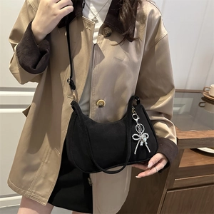 Minimalist black crescent shoulder bag with silver bow charm and adjustable strap