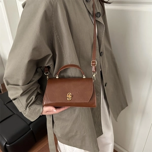Brown vintage faux leather crossbody bag with golden oval clasp and adjustable strap