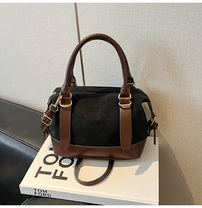 Detail der Wildleder-Boston-Tasche in Schwarz und Braun mit goldener Hardware und Reißverschluss