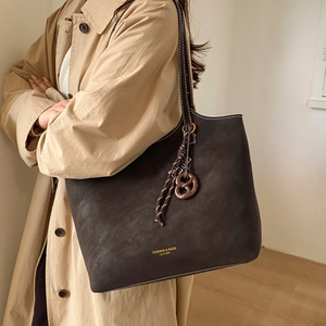 Deep brown large capacity leather tote bag with white stitching and decorative bow