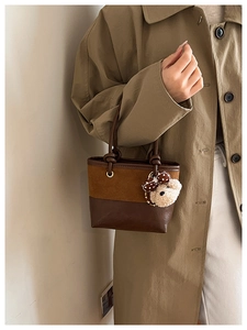 Close-up of vintage brown patchwork bucket bag with cute plush bear charm detail