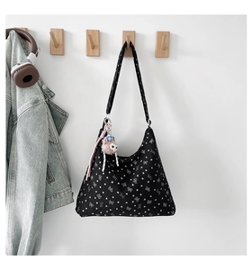Détail du sac bandoulière en velours côtelé noir à nœuds avec petit pendentif agneau en peluche