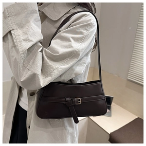 Dark brown faux leather shoulder bag styled with a beige trench coat for a chic office look