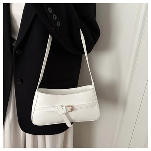Close-up of white PU leather baguette bag featuring a gold metal buckle and sleek strap