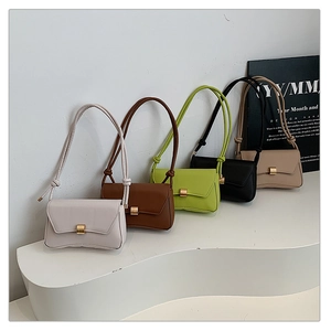 Five minimalist flap bags in diverse colors displayed on a stylish tiered podium