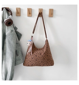 Détail de la texture en velours côtelé marron avec imprimés cœurs et charm peluche