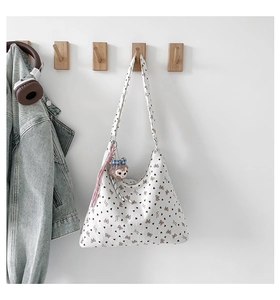 Détail du sac cabas en velours côtelé à fleurs avec un pendentif sur crochet
