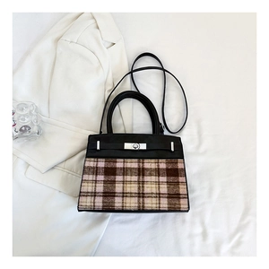 Détail du sac à main à carreaux rose et noir avec fermoir rotatif en métal argenté