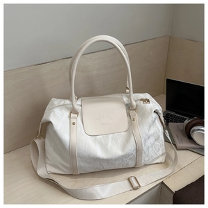 Détail du sac de voyage blanc plissé avec logo HUAJIAO FASHION et ferrures dorées
