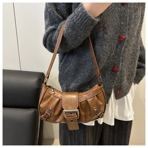 Detailansicht der karamellbraunen Mondsichel-Tasche mit Faltenoptik und Metallschnalle
