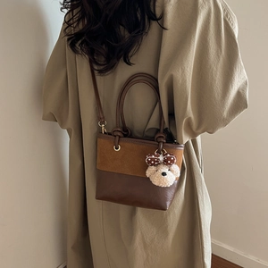 Secchiello vintage marrone con ciondolo a orsetto e cuciture in pelle scamosciata su modella