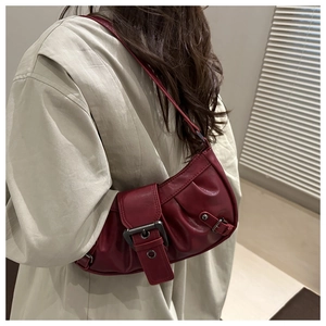 Detail of dark red vintage underarm bag with pleated texture and large metal buckle