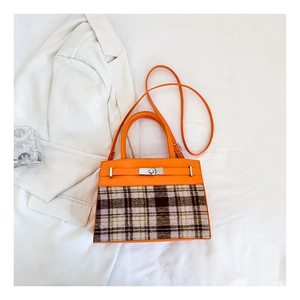 Détail du sac à main en cuir orange et tissu à carreaux avec fermoir métallique