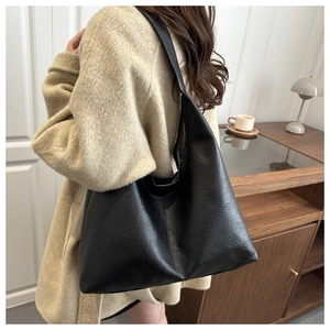 Black large capacity hobo tote bag with textured leather showing natural drape and soft fold