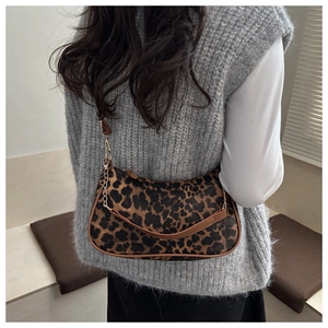 Détail du sac à bandoulière léopard avec bordure en cuir et chaîne dorée