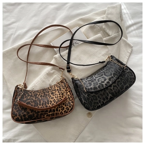 Sac à bandoulière léopard avec chaîne dorée sur fond de tissu au design minimaliste