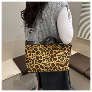 Detail of leopard and rose print tote bag featuring adjustable leather shoulder strap
