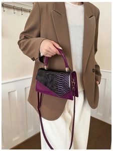 Detail showing elegant purple patent leather and snake pattern patchwork handbag texture