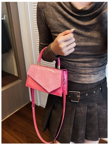 Detailed macro view of bright pink animal-pattern leather handbag with golden hardware