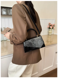 Chic tricolor snake pattern flap handbag with black handle shown in elegant lifestyle setting