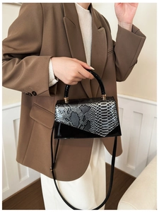 Detail of snake print faux leather handbag worn with a stylish brown blazer for women