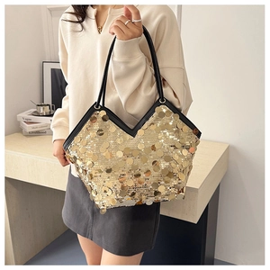 Close-up of a luxury tote bag featuring shimmering gold sequins and black straps