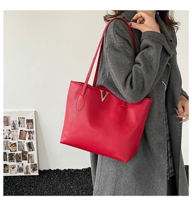 Side view of a red large tote bag with lychee grain leather and golden metal V buckle
