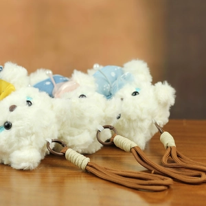 Detailed macro view of plush white bear pendants with floral outfits and braided lanyards