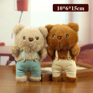 Plush teddy bear keychains in beige and brown wearing corduroy overalls on wooden table
