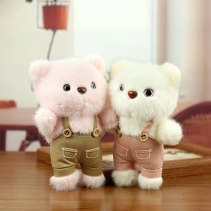 Cute teddy bears in velvet overalls on a wooden surface with a soft blurred background