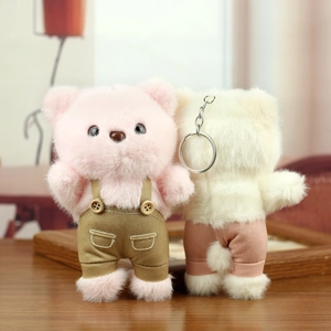 Close-up of cute plush bears in overalls showing front and back views with metal keychains