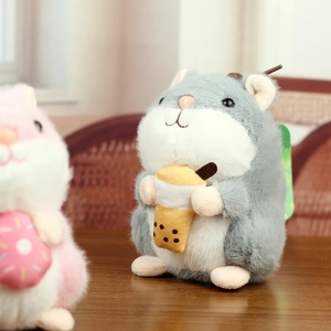 Close-up of cute plush hamster toy holding a bubble tea cup on a wooden surface