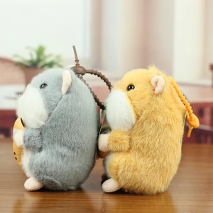 Detail of plush hamster keychains with sunflower seeds on a wooden table surface