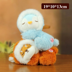 Close-up of cute penguin and fox plush toys with white hoods and closed eyes
