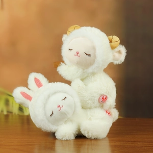 Close-up of soft white plush bunny and sheep dolls with fluffy texture and sleeping eyes