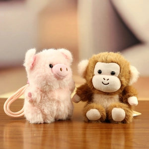 Detail of plush pig and monkey charms showing soft furry texture and sturdy hanging cords