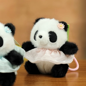 Dettaglio di un portachiavi panda in peluche con vestito di pizzo rosa e decorazione