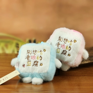 Detailaufnahme der flauschigen Tofu-Plüsch-Anhänger in Rosa und Blau mit Stickerei