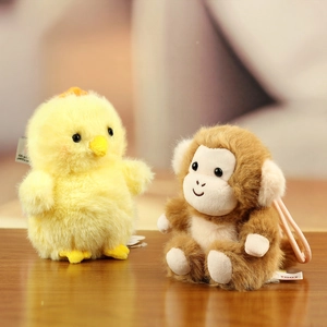 Macro detail of plush monkey and chick charms with soft fur texture and woven pink lanyard