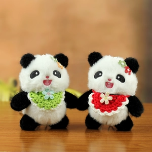 Süße Panda Plüsch-Schlüsselanhänger mit bunten Schals und Blumen auf Holzschreibtisch
